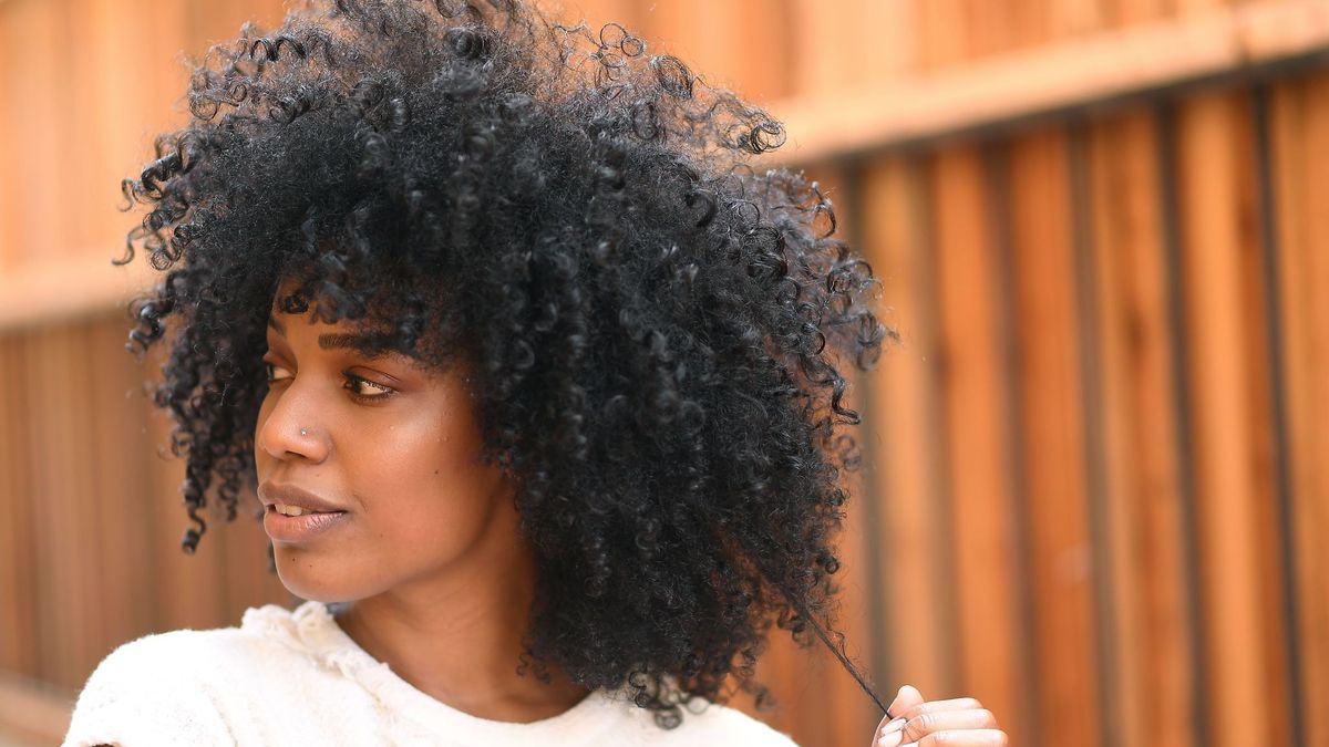 mulher negra com cabelo de permanente afro
